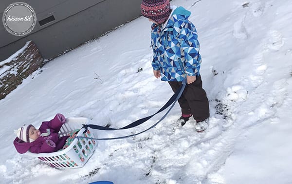 hidegbenisjómóka - két kisgyerek a hóban szánkózásra készen